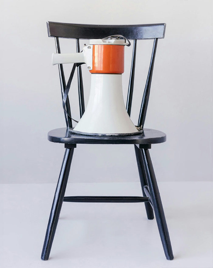 white and red megaphone resting onto of a black wooden chair