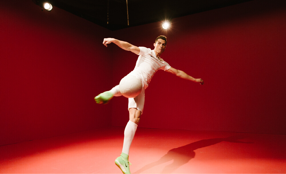 Cristiano Ronaldo kicking a white football in Nike football boots